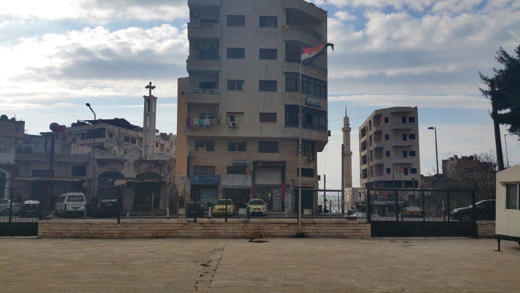 Realität in Syrien: Links ein Kirchturm, rechts ein Minarett, in der Mitte die syrische Flagge
